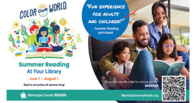 A smiling family sits on a couch reading together. The poster says “Color Our World – Summer Reading at Your Library” from June 1 to August 1.