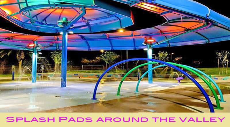 Colorful splash pad at night with glowing rainbow lights and curved water arches, under a large modern shade structure.