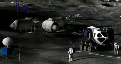 A drawing shows astronauts working near small buildings and vehicles on a dark, dusty surface like the Moon.
