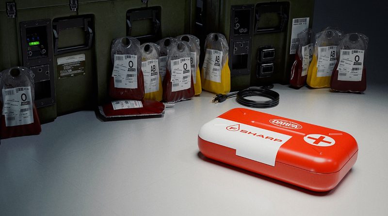 Red and white medical kit labeled 'DARPA SHARP' on a table next to several bags of donated blood in different types.