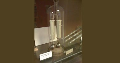 A glass dome display case containing an old scientific instrument called a Demonstration Dry Pile, purchased in 1840.